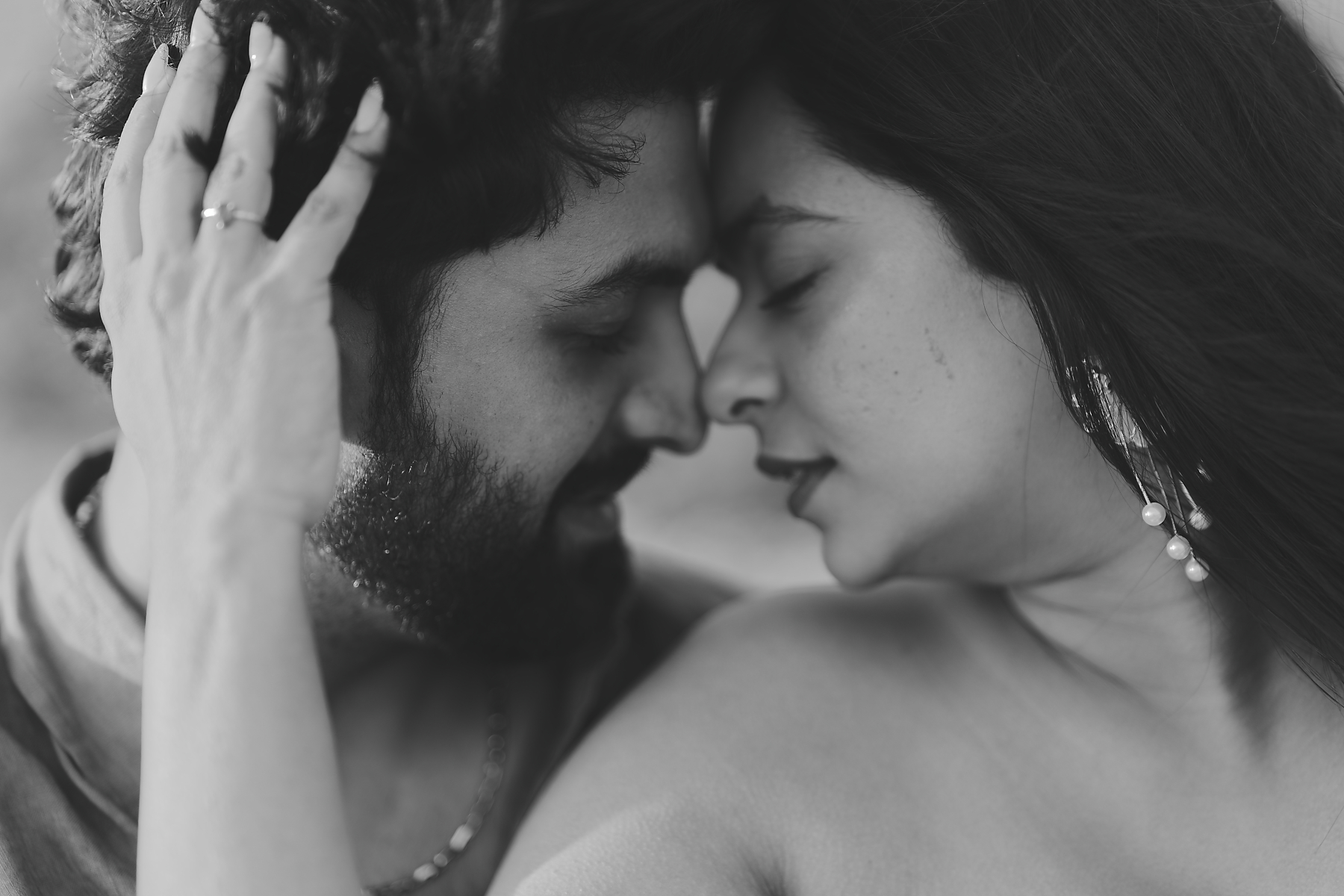 A close-up black and white Cornwall wedding photography A close-up black and white Cornwall wedding photography shot of a couple with closed eyes touching foreheads, his hand in her hair
